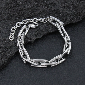 Macro shot of silver titanium steel H-link chain bracelet with lobster clasp on stone