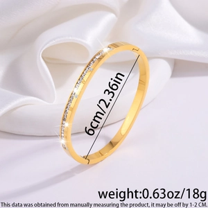 Gold stainless steel bracelet featuring Roman numerals and crystals on a white silk background