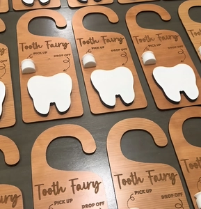 Detail of wooden tooth fairy door hangers with pick up cups and drop off slots