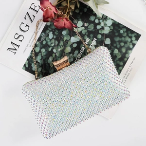 Macro shot of rectangular acrylic evening clutch with colorful rhinestones and gold chain