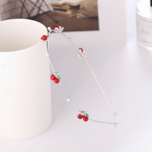 Detailed view of silver metal headband featuring red cherry charms and white faux pearls