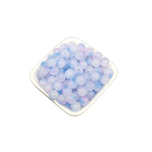 Macro shot of 8mm blue and purple gradient glass beads in a white square bowl
