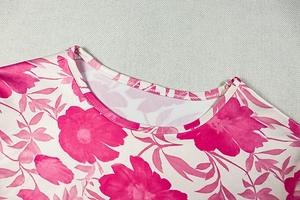 Détail du col rond et de l'imprimé floral rose sur une robe ajustée à manches longues