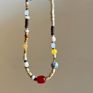 Nahaufnahme einer handgefertigten Boho-Kette mit roten Perlen und Leopardenmuster