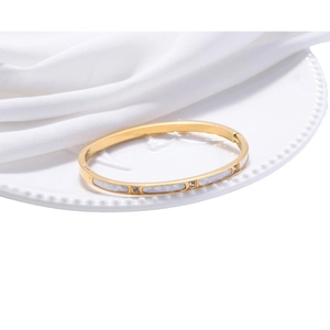 Fashionable rose gold titanium steel bracelet with white shell inlay and rhinestones on a tray