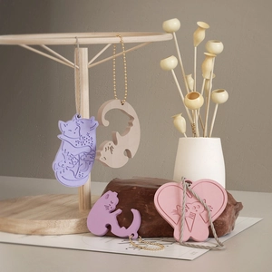 Artistic display of cat and heart shaped resin charms in pastel colors with metal chains