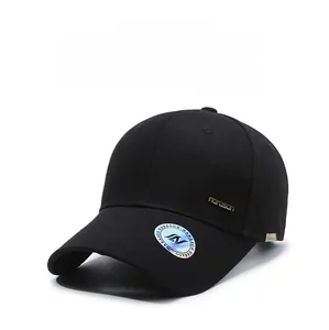 Detail of black baseball cap showing golden metal logo and premium cotton texture