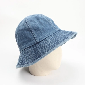 Detailed view of blue washed denim bucket hat with reinforced stitching on a model