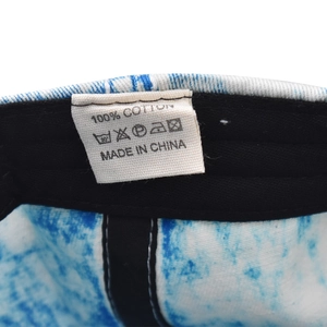 Detail des Etiketts aus 100 % Baumwolle und der Pflegehinweise in der Denim-Baseballkappe