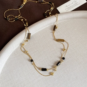 Close-up of vintage tiger eye stone beaded necklace on a premium textured display tray
