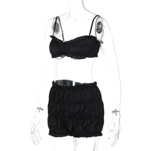 Detail view of black satin pleated crop top and high-waisted shorts lounge set