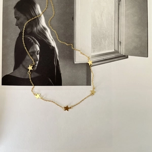 Artistic detail of gold five-point star pendant necklace displayed on a portrait photo