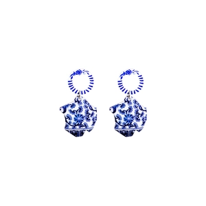 Detail of acrylic blue and white porcelain earrings with geometric ring design