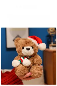 Close-up of soft plush brown teddy bear wearing a Christmas hat and striped scarf