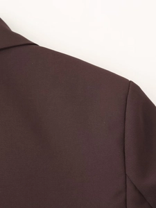 Dettaglio della spalla e della trama del tessuto di un blazer marrone in stile urbano