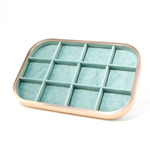 Detail of 12-compartment champagne gold jewelry tray with mint green velvet lining