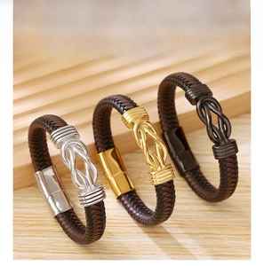 Detail of woven leather bracelets with metallic knot charms in gold, silver, and black