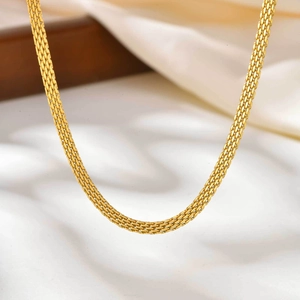 Macro detail of golden mesh chain necklace showing fine woven texture and metallic luster