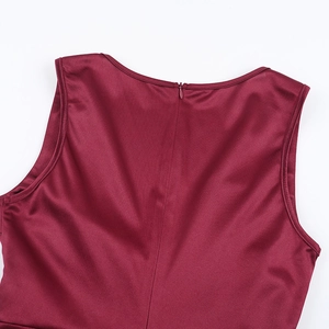 Détail de la fermeture éclair invisible sur une robe en satin bordeaux au tissu soyeux