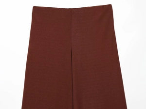 Detail view of high waist wide leg trousers in dark burgundy with fine fabric texture