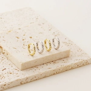 Detailed shot of gold and silver S925 sterling silver hoop earrings with small crystals