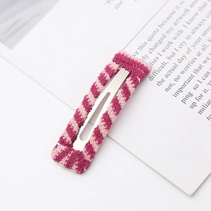 Close-up of pink striped knitted hair clip with silver metal BB clip structure