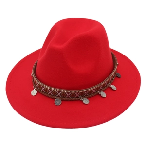 Detail of red wool felt fedora featuring ethnic woven band and silver coin pendants