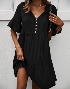 Détail d'une robe noire à col en V avec boutons blancs et ourlet à volants élégant