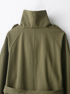 Close-up of military green trench coat back detailing with cotton twill texture
