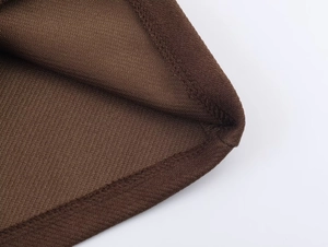Detail shot of high-quality flatlock stitching and knit texture on dark brown romper