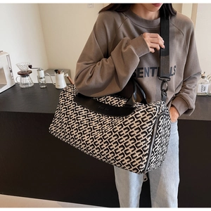 Dettaglio della borsa da viaggio grande con motivo geometrico bianco e nero e cuoio