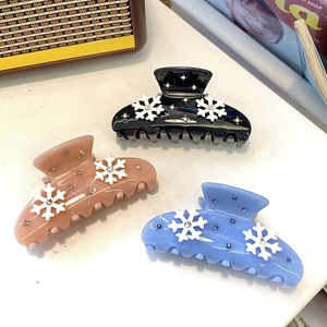 Pink, blue, and black acetate hair claws with snowflake patterns and small rhinestones