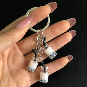 Close-up of three miniature bubble tea resin charms on a silver metal keychain ring
