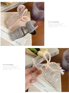 Detail showing translucent bow-shaped hair claw clips in dusty pink and smoky grey colors