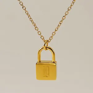 Macro view of gold minimalist padlock pendant necklace with engraved letter D