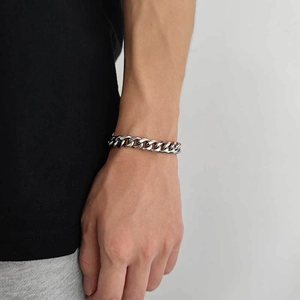Polished 11mm stainless steel Cuban link bracelet worn by a male model for hip-hop style
