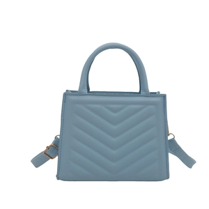 Light blue quilted leather crossbody lady bag with elegant top handles and gold hardware