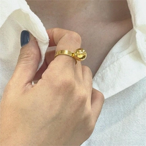 Minimalist gold ball ring on hand with a modern 925 sterling silver band design