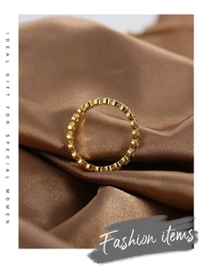 Detail of gold plated brass ring with micro-set white zircons on brown silk fabric