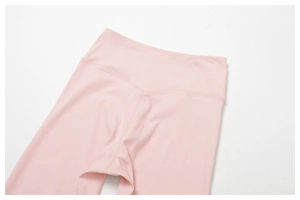 Détail d'un pantalon de yoga taille haute en tissu rose élastique et coutures lisses