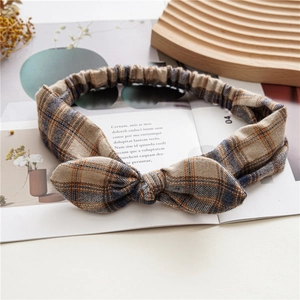 Close-up of checkered bunny ear headband with elastic band on rustic magazine background