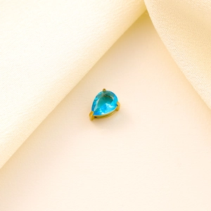 Detailed macro view of a light blue teardrop zircon pendant with elegant golden claw setting