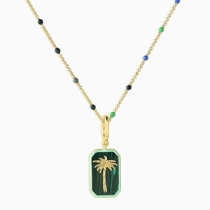 Close-up of gold palm tree pendant with malachite green texture and colorful beads