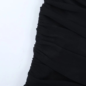 Détail du tissu en maille froncée et coutures latérales sur ce top caraco noir