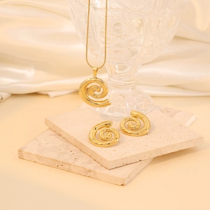 Detailed view of irregular geometric gold necklace and stud earrings set on stone pads