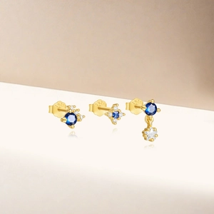 Detailed shot of S925 sterling silver gold earrings with blue stones and star charm