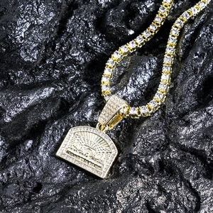 Close-up of gold plated cross chain with Last Supper pendant and sparkling rhinestones