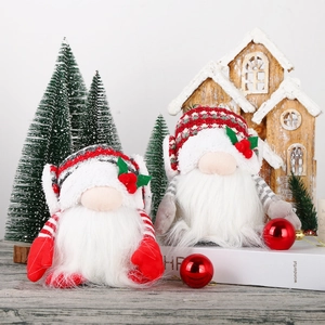 Pair of festive Christmas faceless gnomes with knit hats on white books background