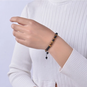 Détail du bracelet code Morse avec pierre mate et œil de tigre sur le poignet