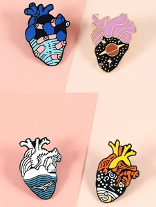 Detail of creative anatomical heart enamel pins featuring starry sky and whale designs